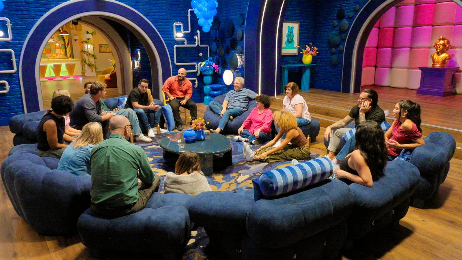 The cast gathered on round blue sofas in the factory lounge, Nick Spinelli seated in a black vest